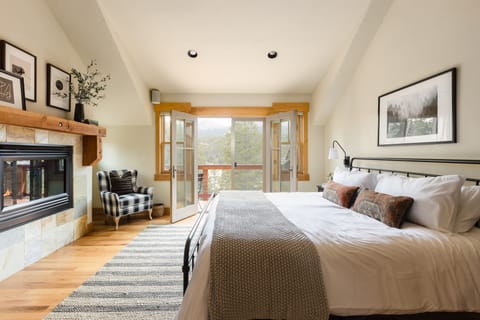 A spacious Primary Bedroom with a balcony and fireplace.