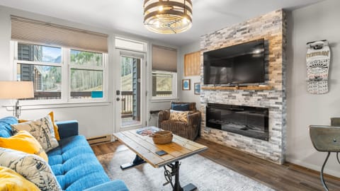 Cozy living room with mountain views and a stone fireplace.