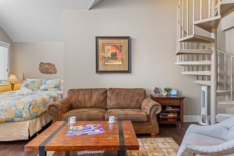 The living room has a sleeping area with a queen-size bed.