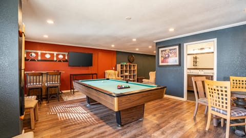 Game room with a TV, bar area, and pool table, featuring an attached full bathroom.