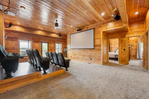Theater room with a projector screen and theater seating.