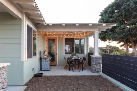 The backyard has a grill, dining table, and fairy lights for the perfect dinner party.