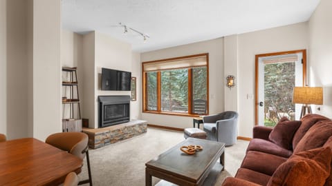 Cozy living room with a fireplace and picture-perfect forest views — your Telluride retreat starts here.