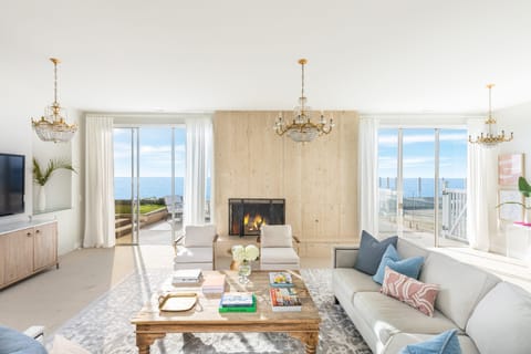 The living room features a fireplace and sweeping views.