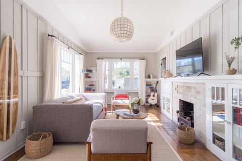 Living room features comfy seating and surf vibes.