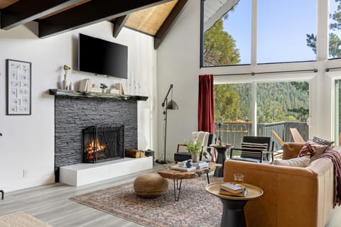 Indoor fireplace and two-story windows.