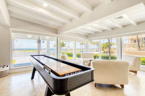 Bright front living room with huge windows and a shuffleboard table!