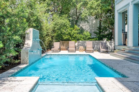 Backyard oasis features a pool with loungers and a relaxing water feature.