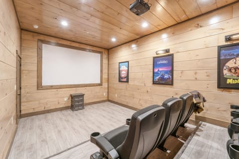 Movie room with a projector screen and theater seating.