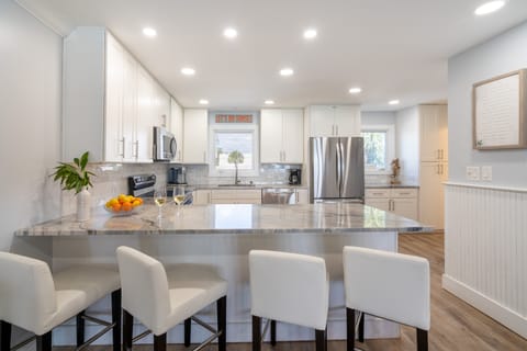 Sleek kitchen with modern appliances and barstool seating.