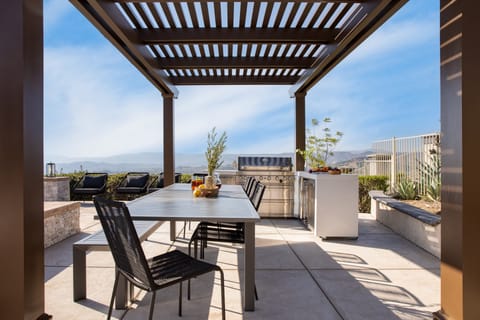 Outdoor dining table and grill near the pool.