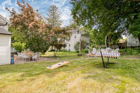 Large yard with a hammock and cornhole.