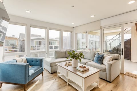 Living room features tons of natural light and a sleeper sofa.