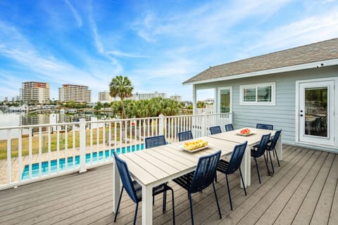 Upper deck features a BBQ grill and a large outdoor dining table.