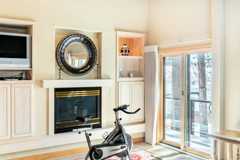 Primary bedroom features a fireplace and a Peloton bike.