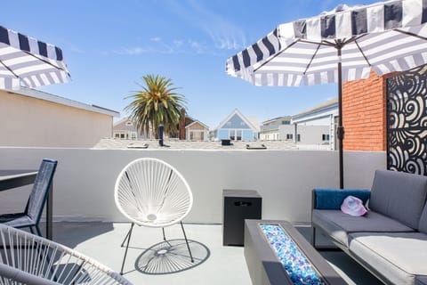 Sunny balcony with comfortable seating and a firepit.