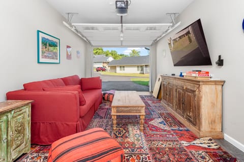 Finished garage lounge with a queen-size sofa bed and a TV.