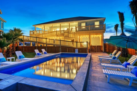 House lights illuminating the pool at night.