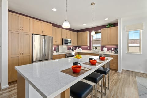 Fully equipped kitchen with modern appliances and barstool seating.