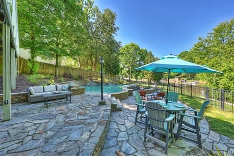 Bar top table with shade, pool loungers and Adirondack seating on the pool deck.