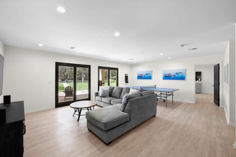 Lower Level game room with Tv, sectional and ping pong table.