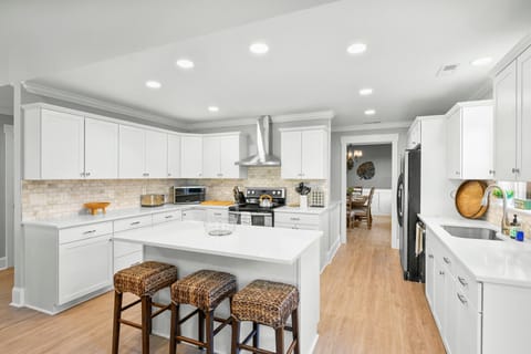 White kitchen with an island as a centerpiece.