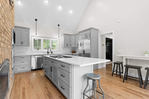 Fully equipped kitchen with a gas range and barstool seating.