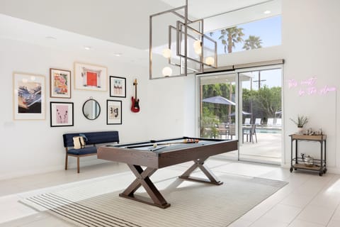 Bright game room leads outdoors and features a pool table.