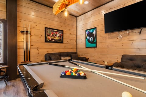 Game room with a pool table and TV.