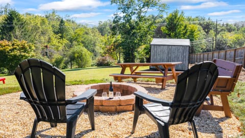 Backyard with firepit, lounge, and outdoor dining table.