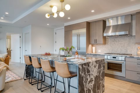 Fully equipped kitchen with barstool seating at the island counter.