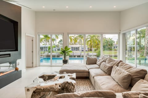 The living room offers cozy seating, a beautiful view of the pool, patio access and plenty of natural light.