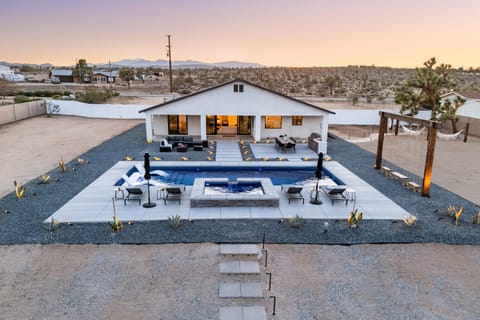 Featuring a sparkling pool, multiple lounging areas, custom swing set, and serene mountain views.