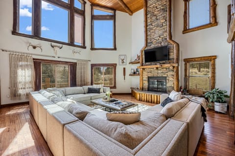 A soaring lodge-style living room with exposed beams and a statement fireplace—your cozy retreat awaits.