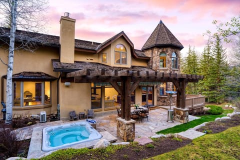 Backyard with a hot tub and outdoor dining table.