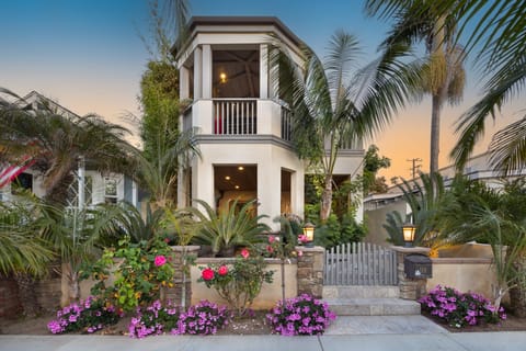 A picture-perfect exterior with lush palms and a golden sky.