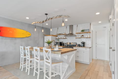 Modern kitchen with barstool seating and pendant lighting.