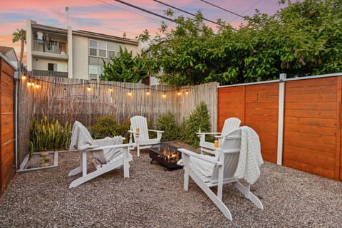 Shared Adirondack chairs and a fire pit under glowing sunset skies.