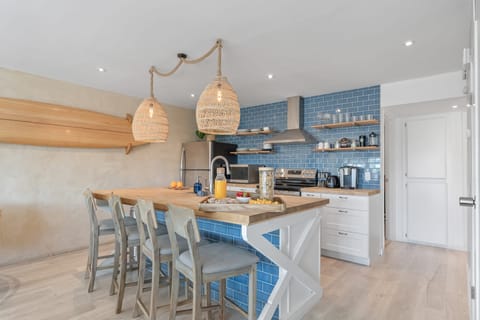 Modern kitchen with Bar seating, pendant lights, and a beachy blue palette.