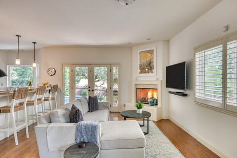 Cozy living room with fireplace, smart TV, plush seating, and easy access to the outdoors.
