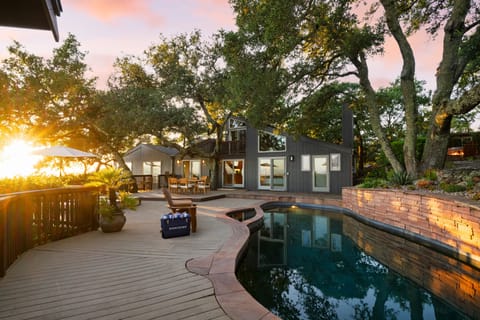 An inviting outdoor pool area surrounded by lush oak trees.