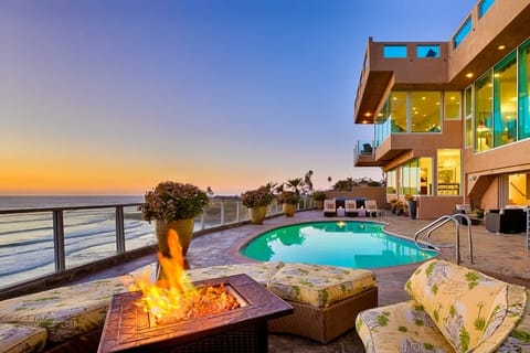 Lounge poolside by the fire pit with stunning ocean views.