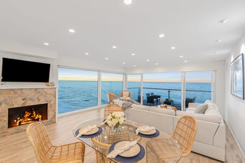 Inviting living room featuring a fireplace, TV, and panoramic ocean vistas.