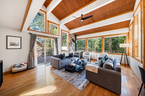 Great room living area with vaulted wood-beam ceiling and large windows.