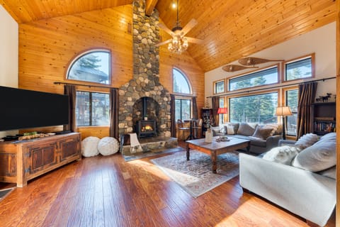 Spacious living room with cozy sofas, a TV, a fireplace, and board games for endless family fun.