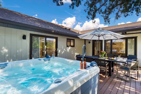 Hot tub for unwinding and a spacious deck with outdoor dining, perfect for al fresco meals.