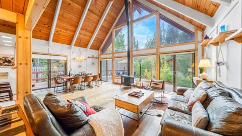 Open-concept living room with vaulted ceilings and a dramatic wall of windows.