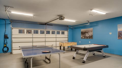 Game garage with ping pong table, foosball, air hockey, and arcade games.