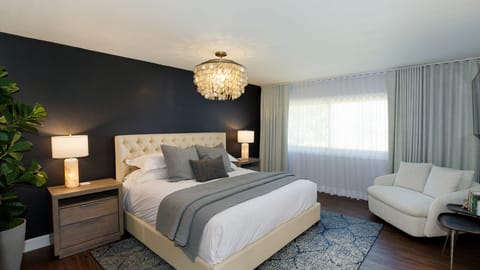 The primary bedroom features a king bed, TV, walk-in closet, and an ensuite bathroom.