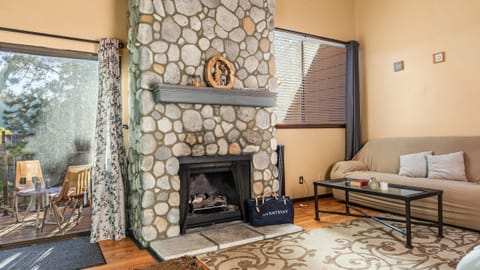 Living area with a stone fireplace and cozy seating area.